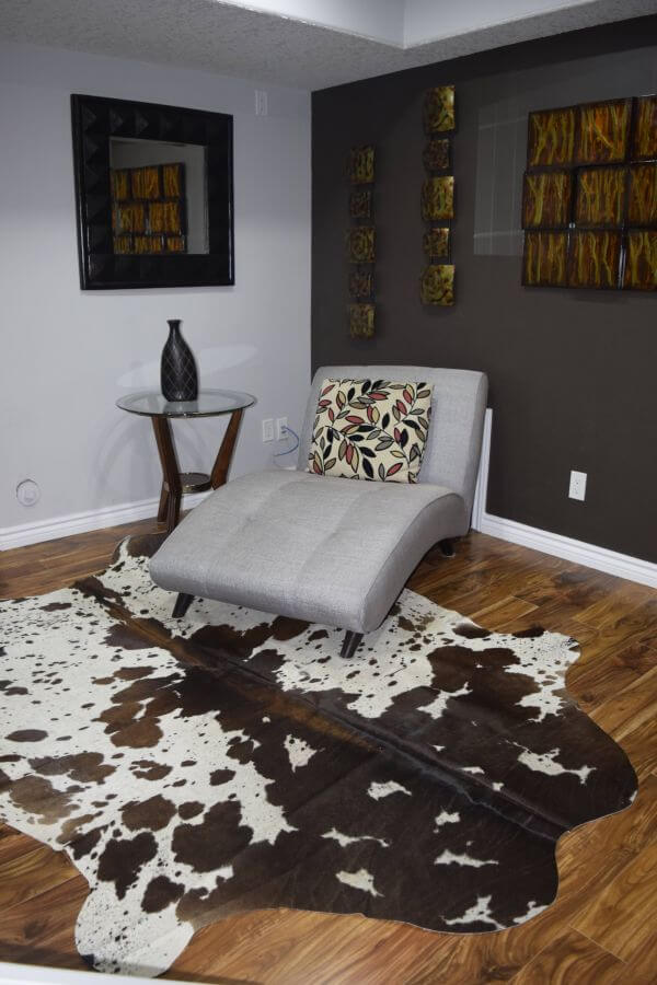 tricolor cow rug in living room with wood floors